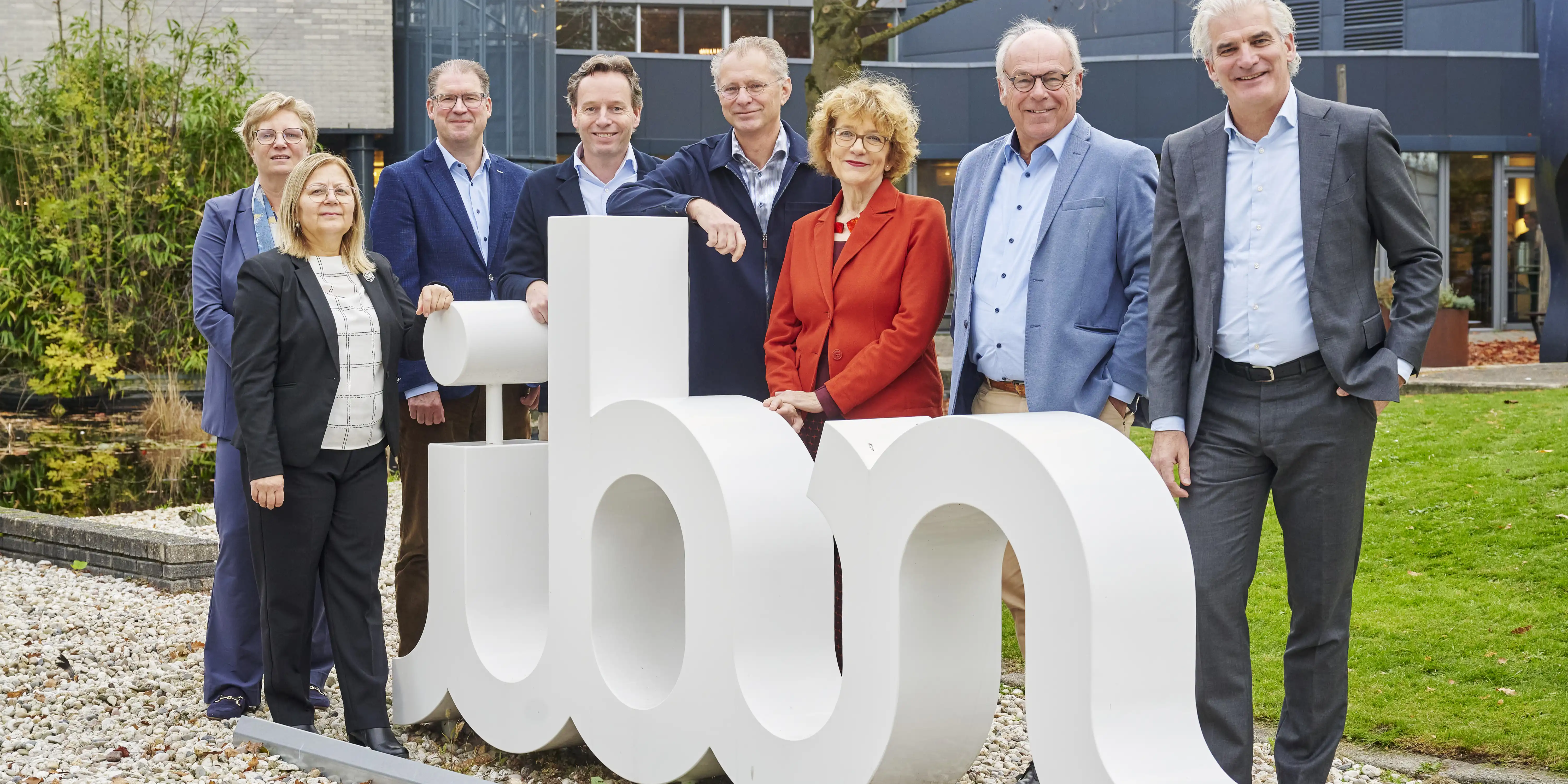 Leden Raad van Commissarissen op een rij voor het logo van IBN