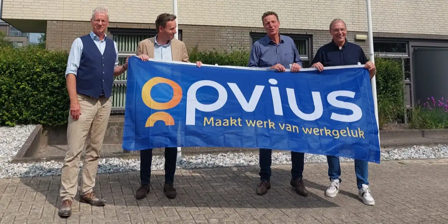 Aandeelhouders en directie Opvius op de foto met een vlag waar het logo op staat.