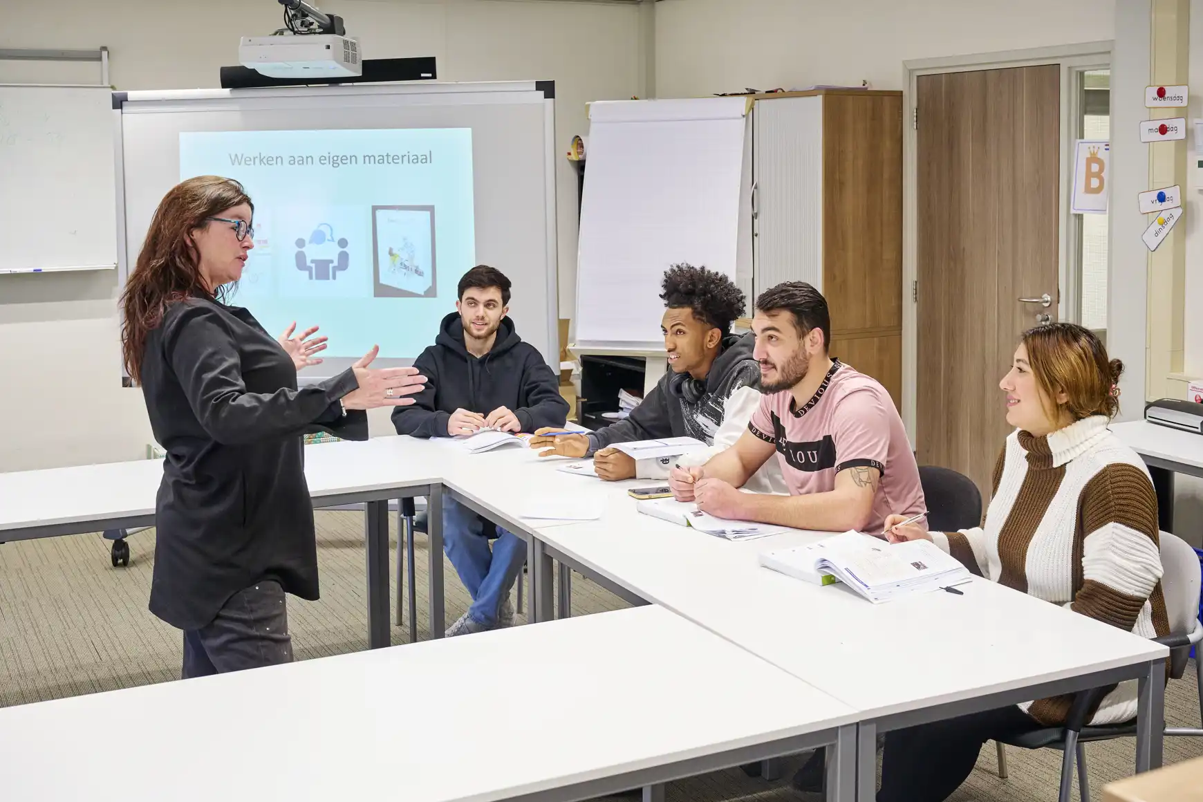 De jonge statushouders volgen een les bij Mirjam