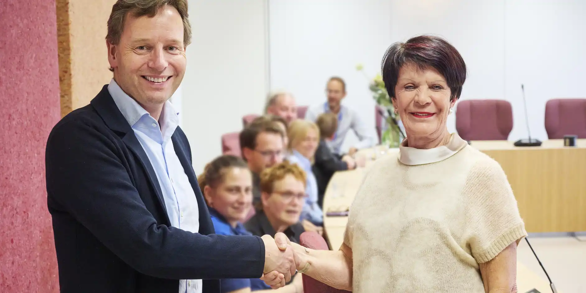 Algemeen directeur Maarten Gielen en Willy Hendriks-van Haren schudden elkaar de hand op de nieuwe overeenkomst
