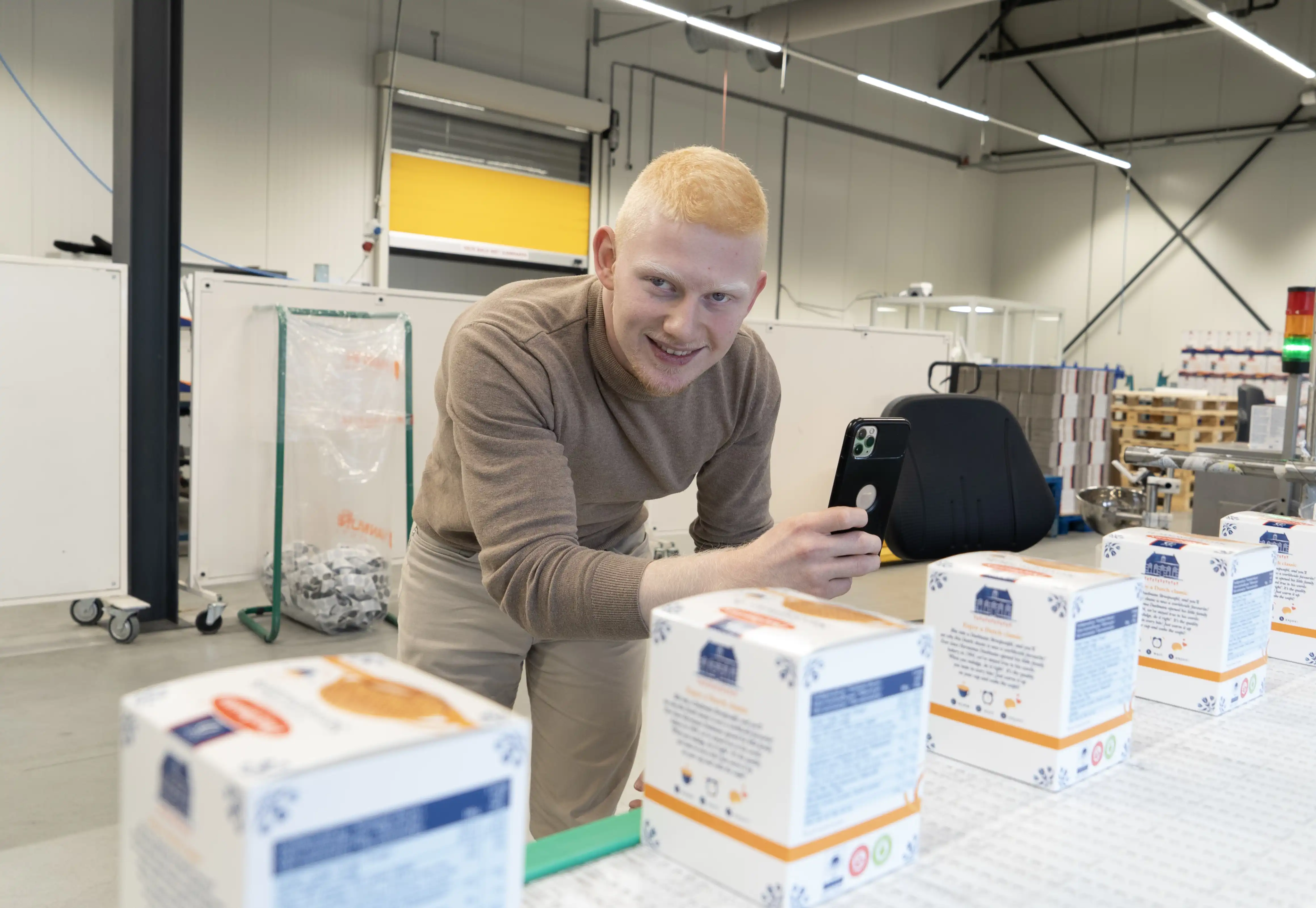 Hasan in de productielocatie waar hij een foto maakt van de producten