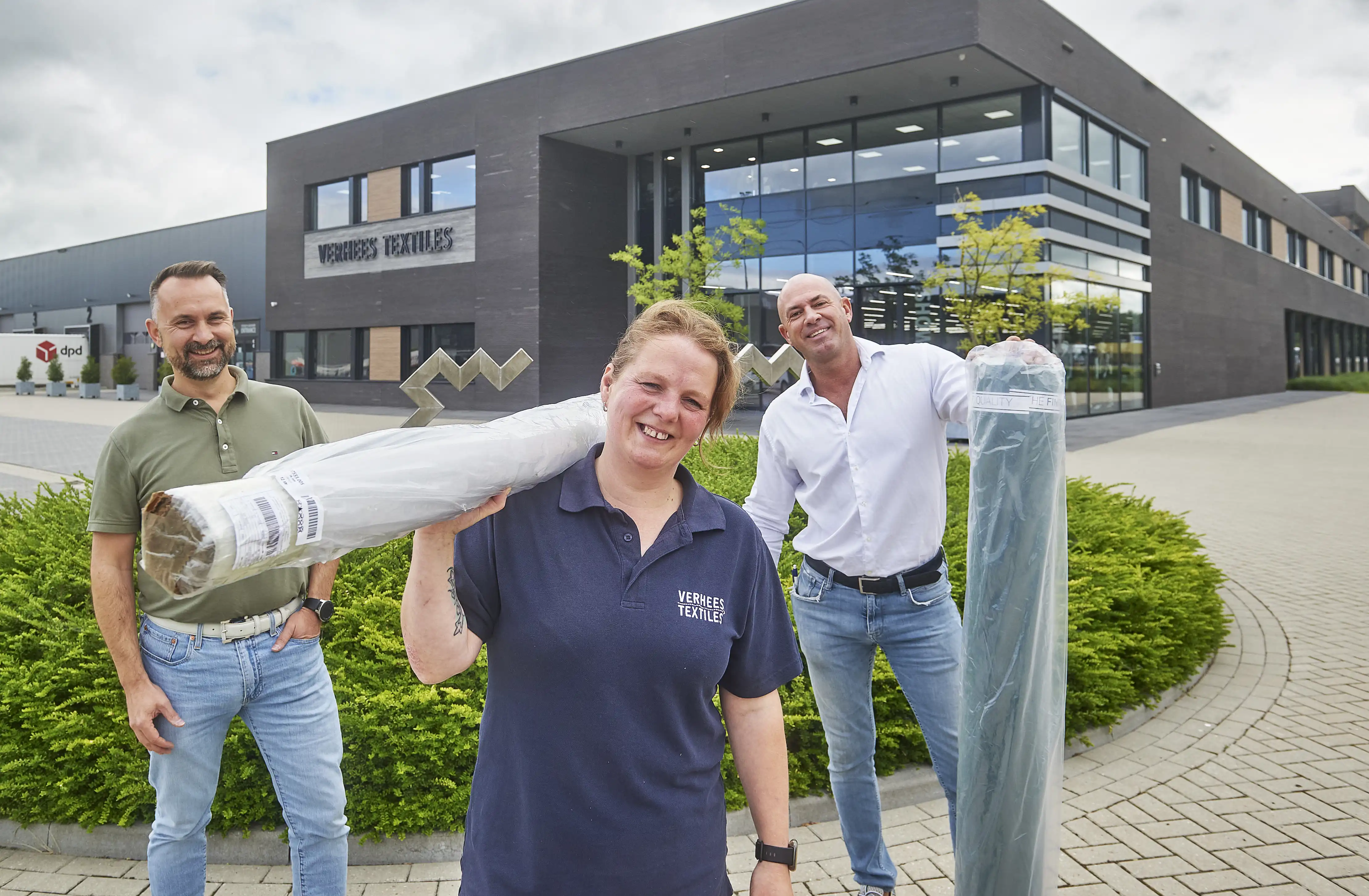 Jowan Walters, Carina Snoek, Sven van Gorp (warehouse manager) voor het pand van Verhees Textiles