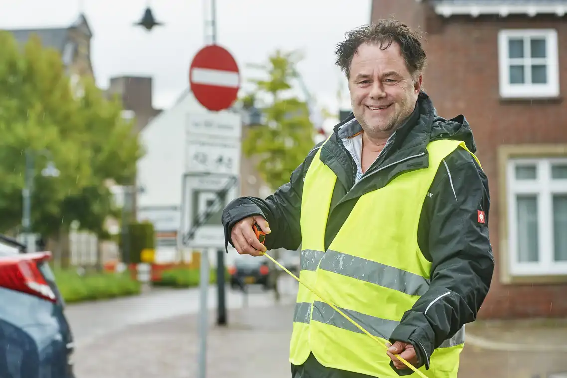 Louis met een rolmaat in zijn hand vertelt over zijn verhaal naar werk