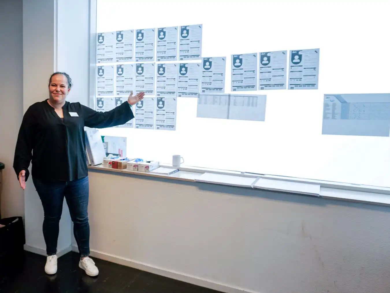 Samira bij het raam met daarop de 'wie ben ik' formulieren