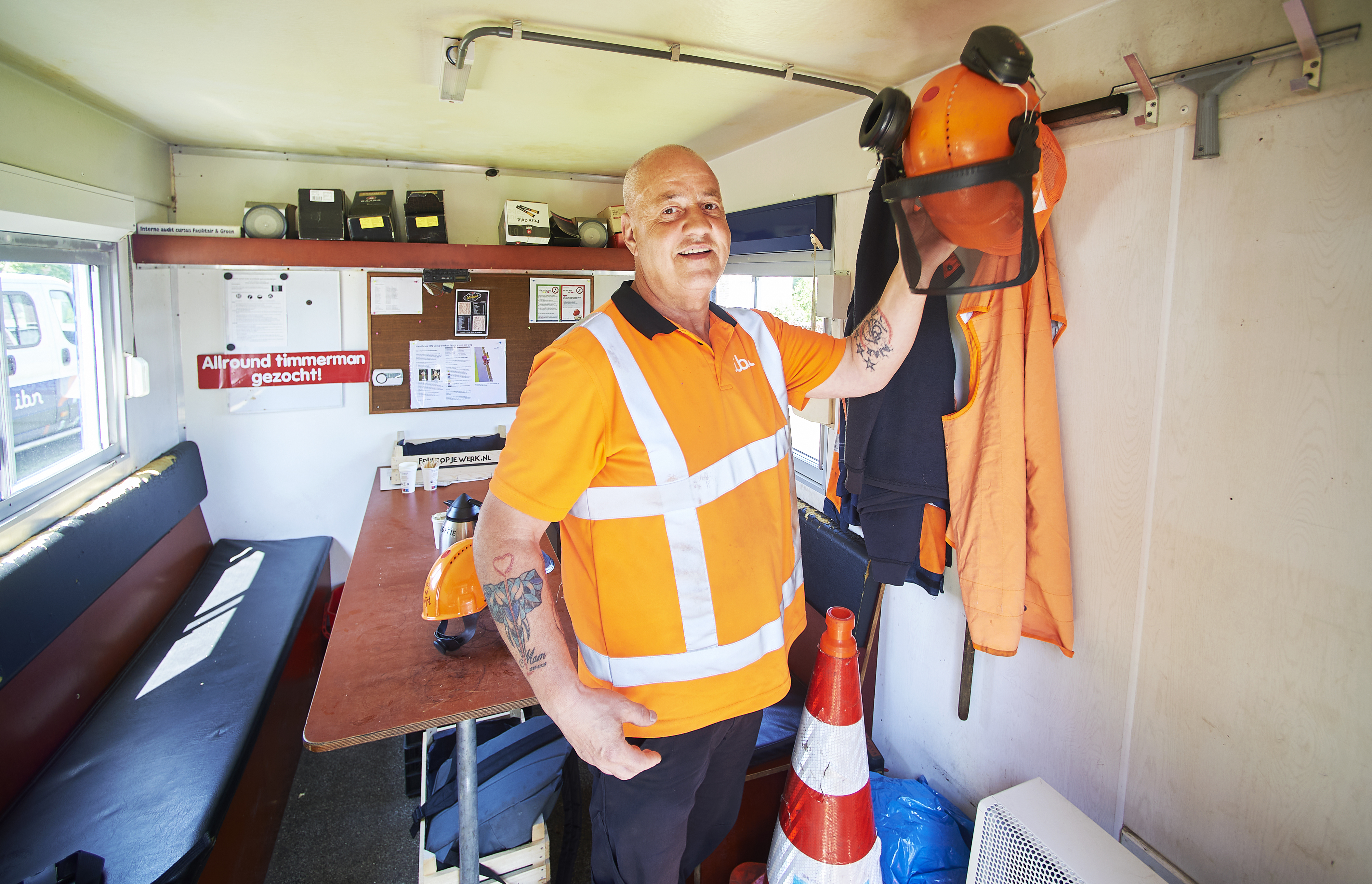 Jos hangt zijn jas op in de keet