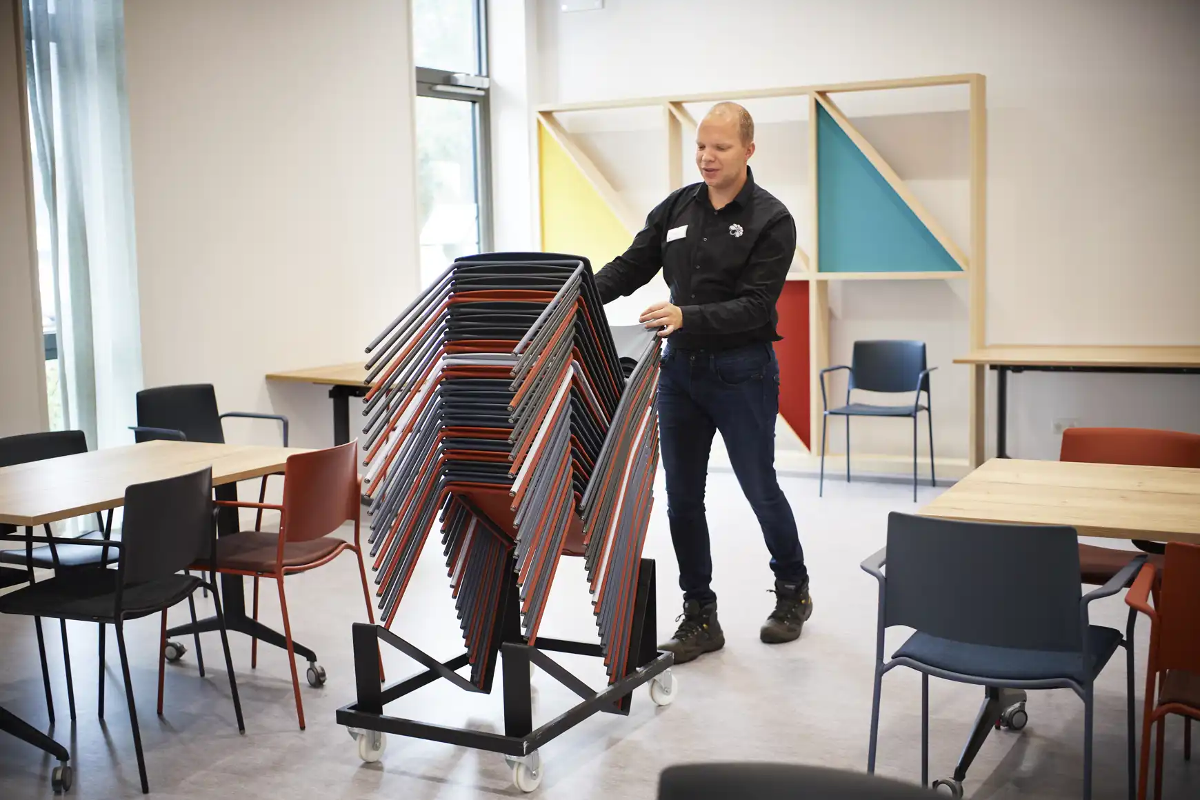 Melvin ruimt stoelen op bij Ontmoetingsplein Mellepark