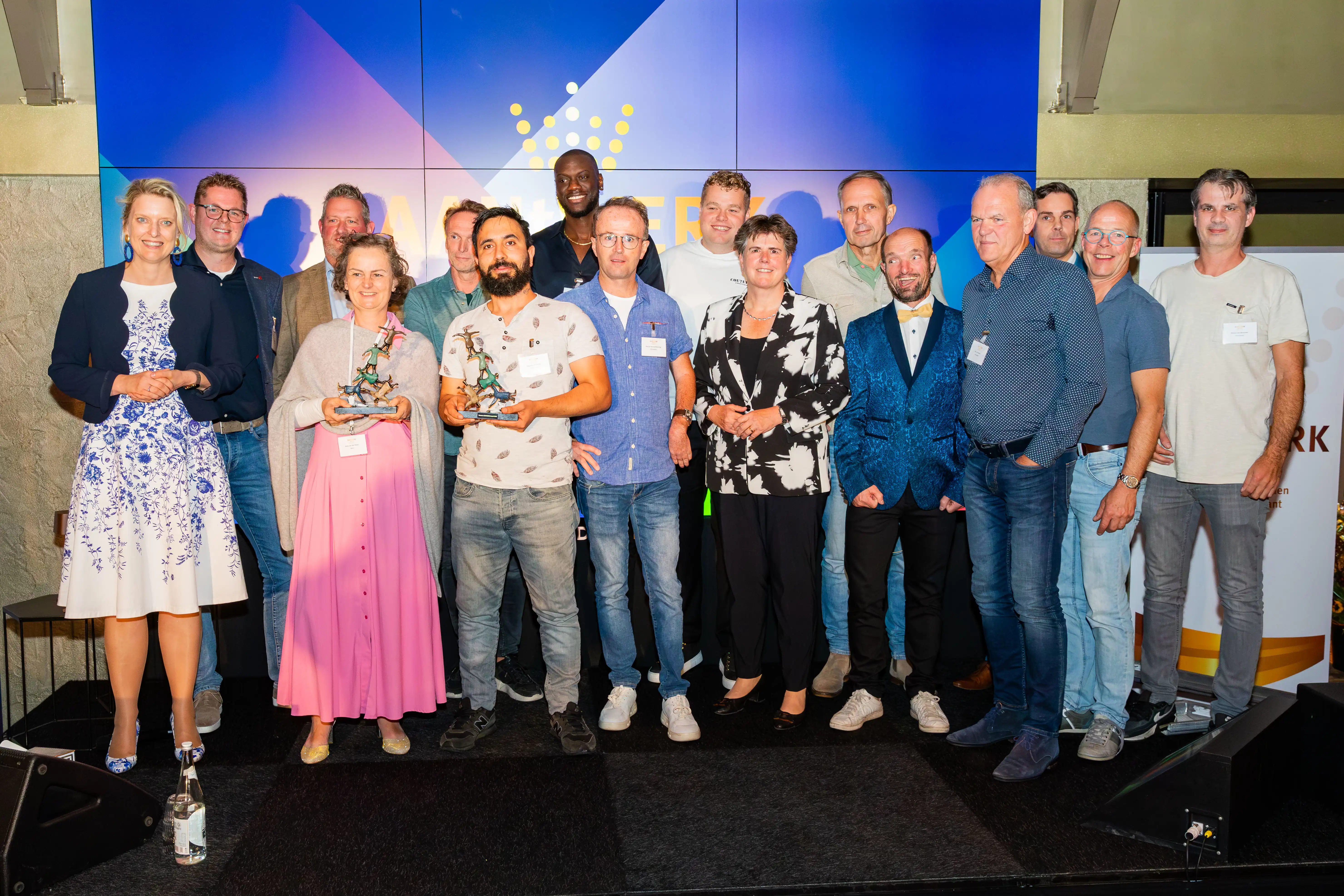 Prijswinnaars op het podium met de prijen vast in hun handen