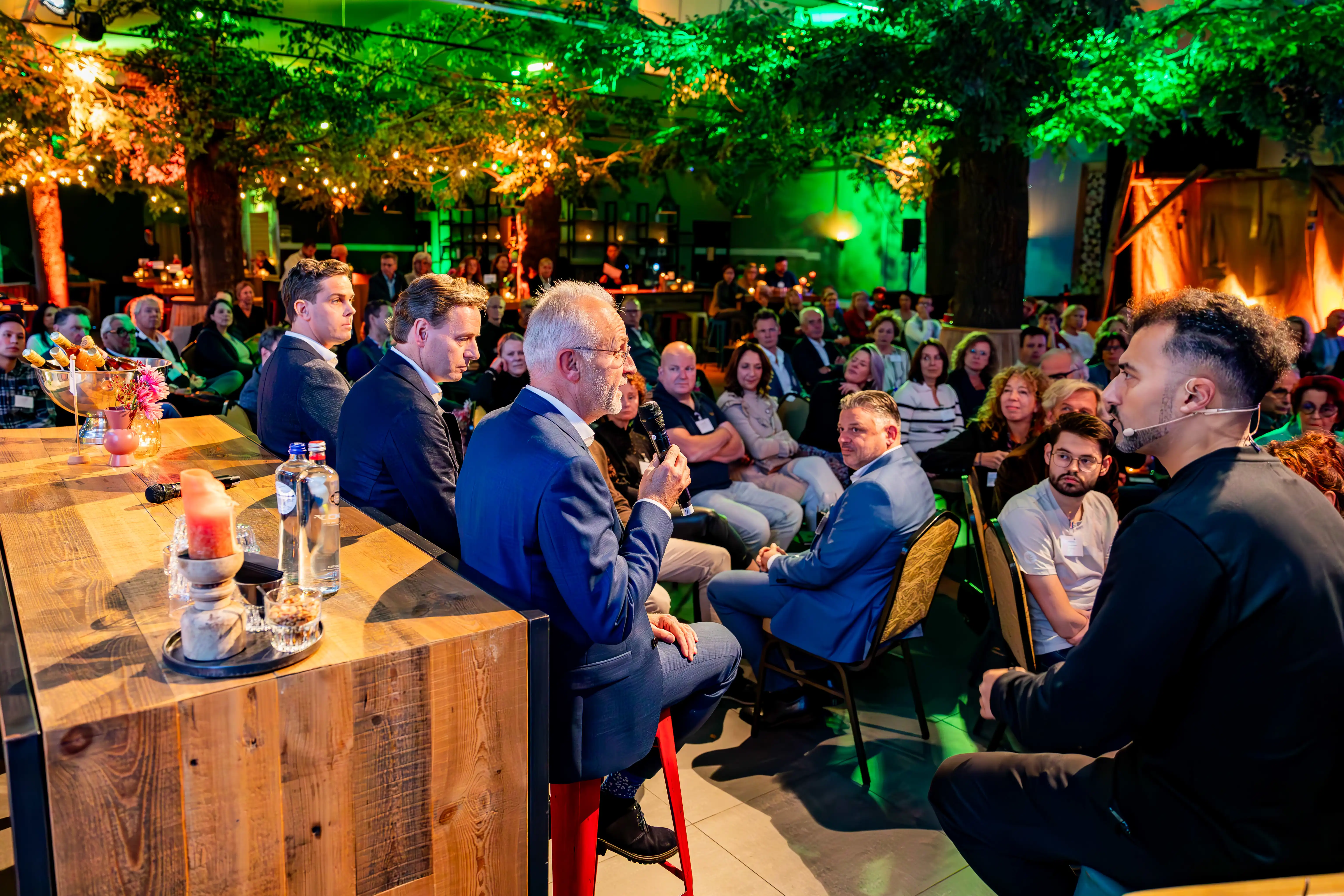 Özcan Akyol luistert aandachtig naar de ondernemers die hun verhaal delen op het podium