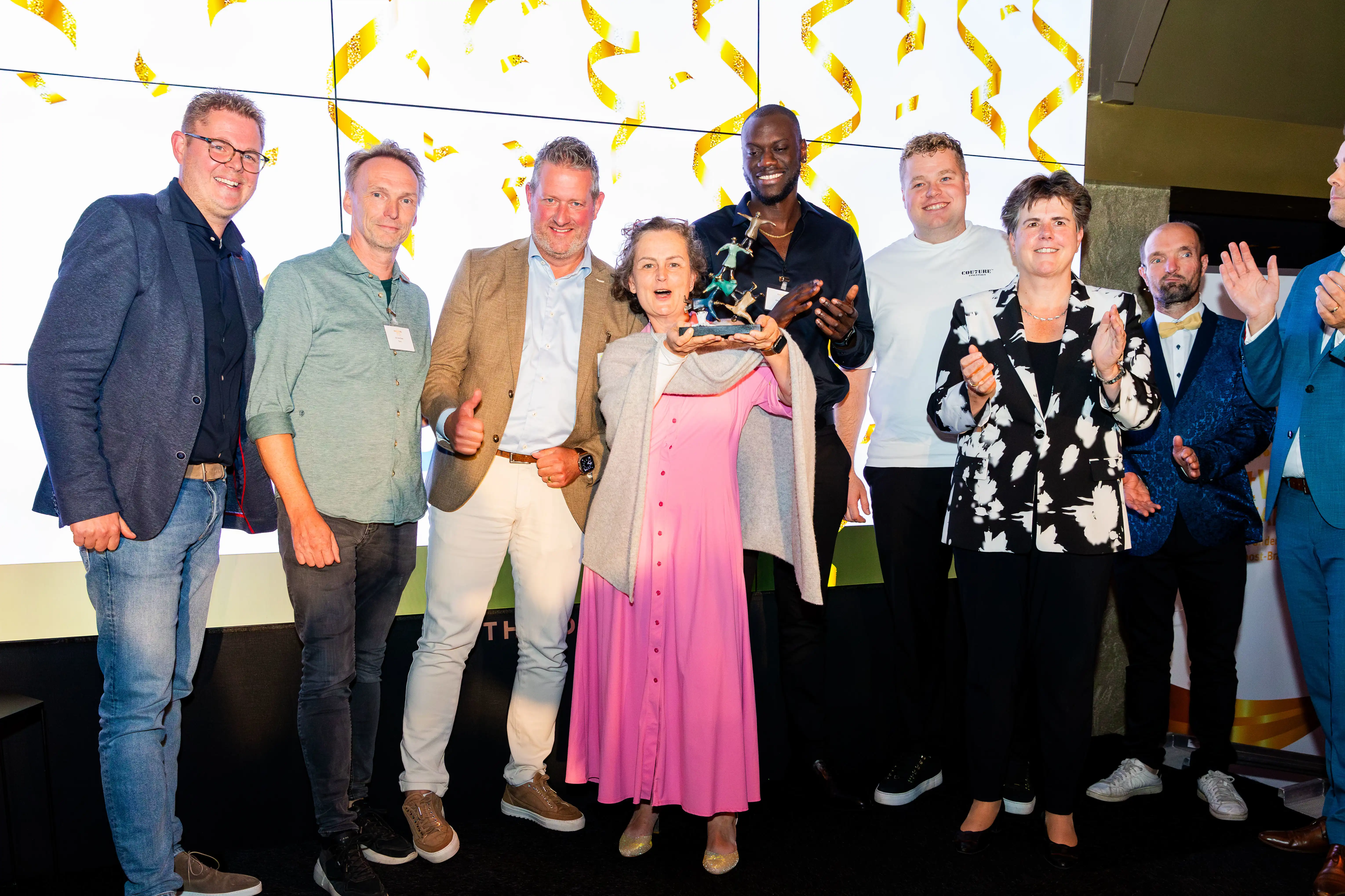 winnaar op de foto met trofee in handen