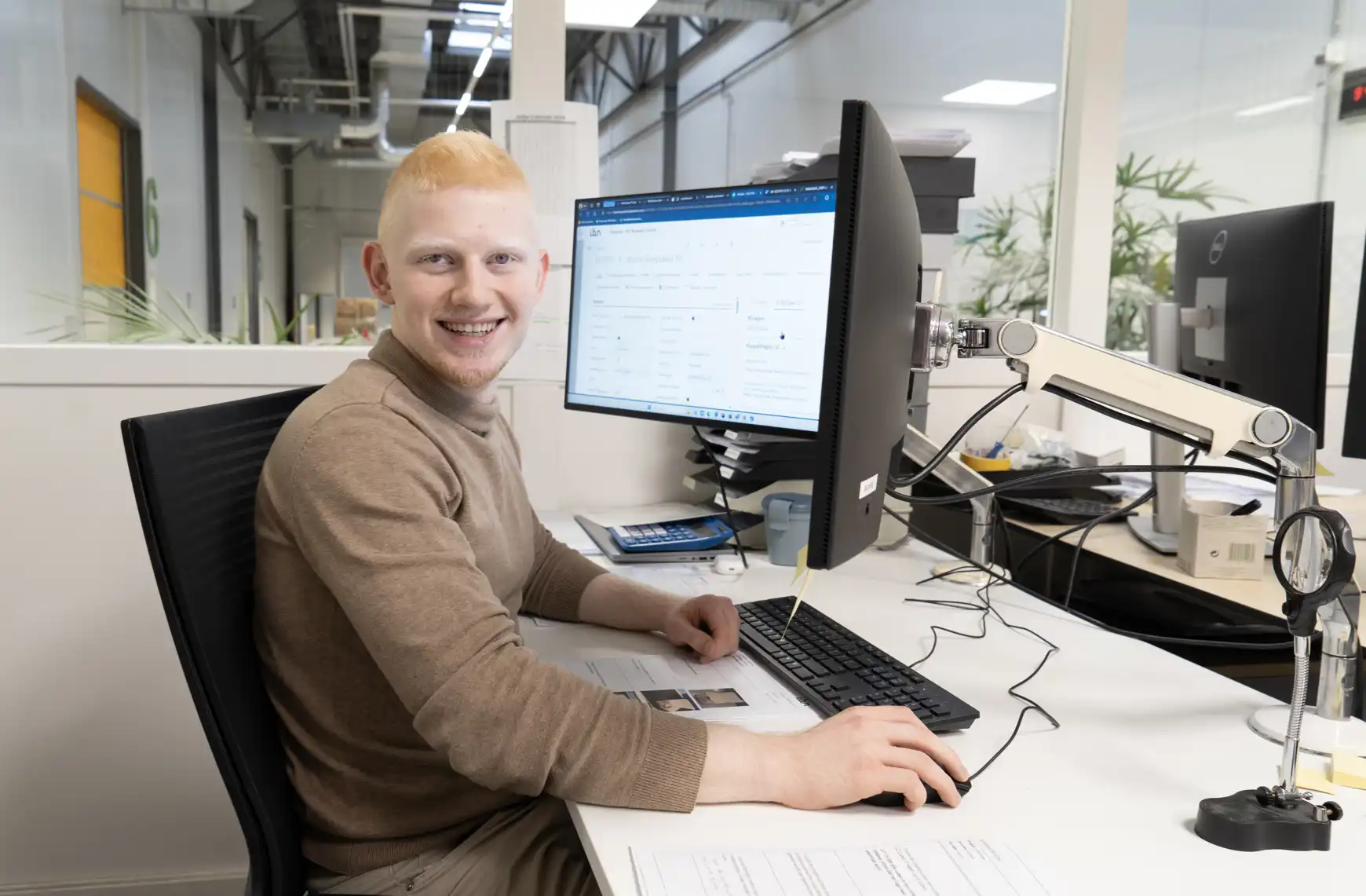 Hasan op zijn werkplek achter de computer