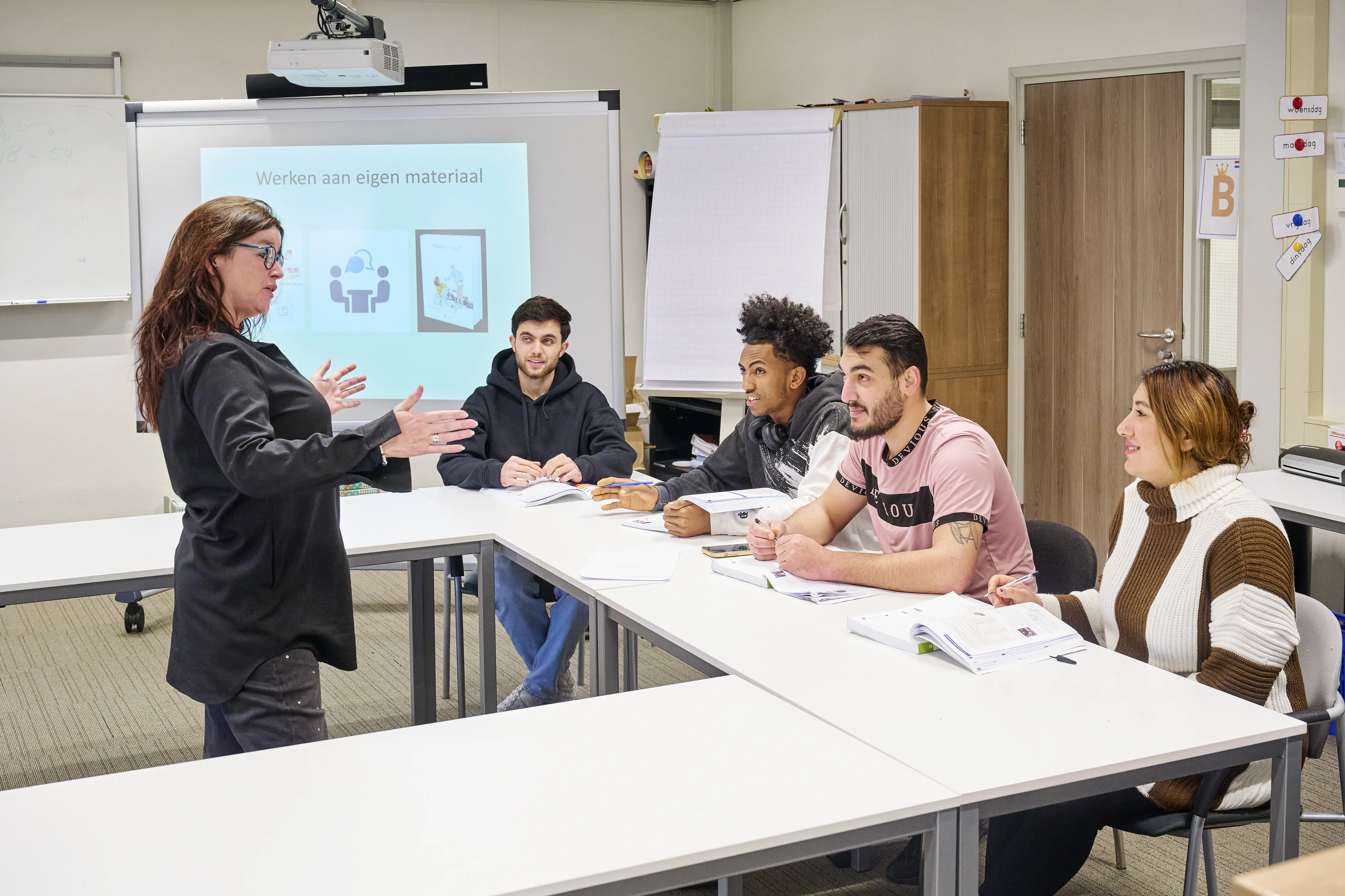 De jonge statushouders volgen een les bij Miriam